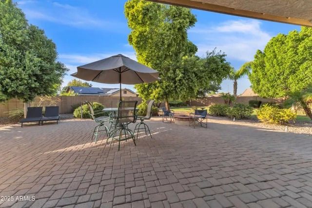 a view of a patio with a table and chairs under an umbrella