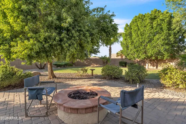 a patio with table and chairs and potted plants