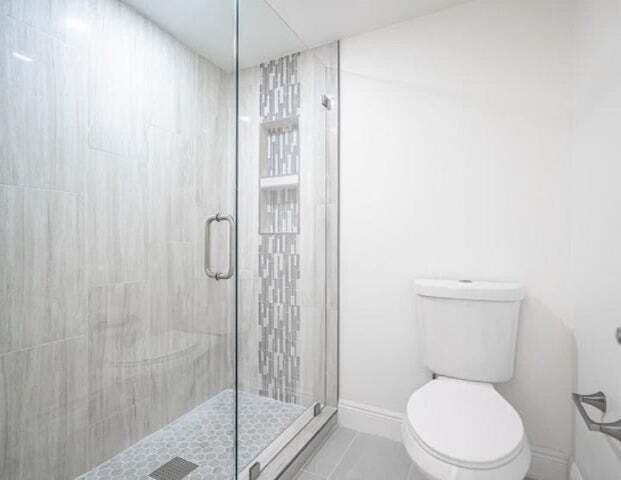 9284 Vista Del Lago, Unit 34F Boca Raton, FL 33428 - Photo 5 of 15 a white toilet sitting next to a shower