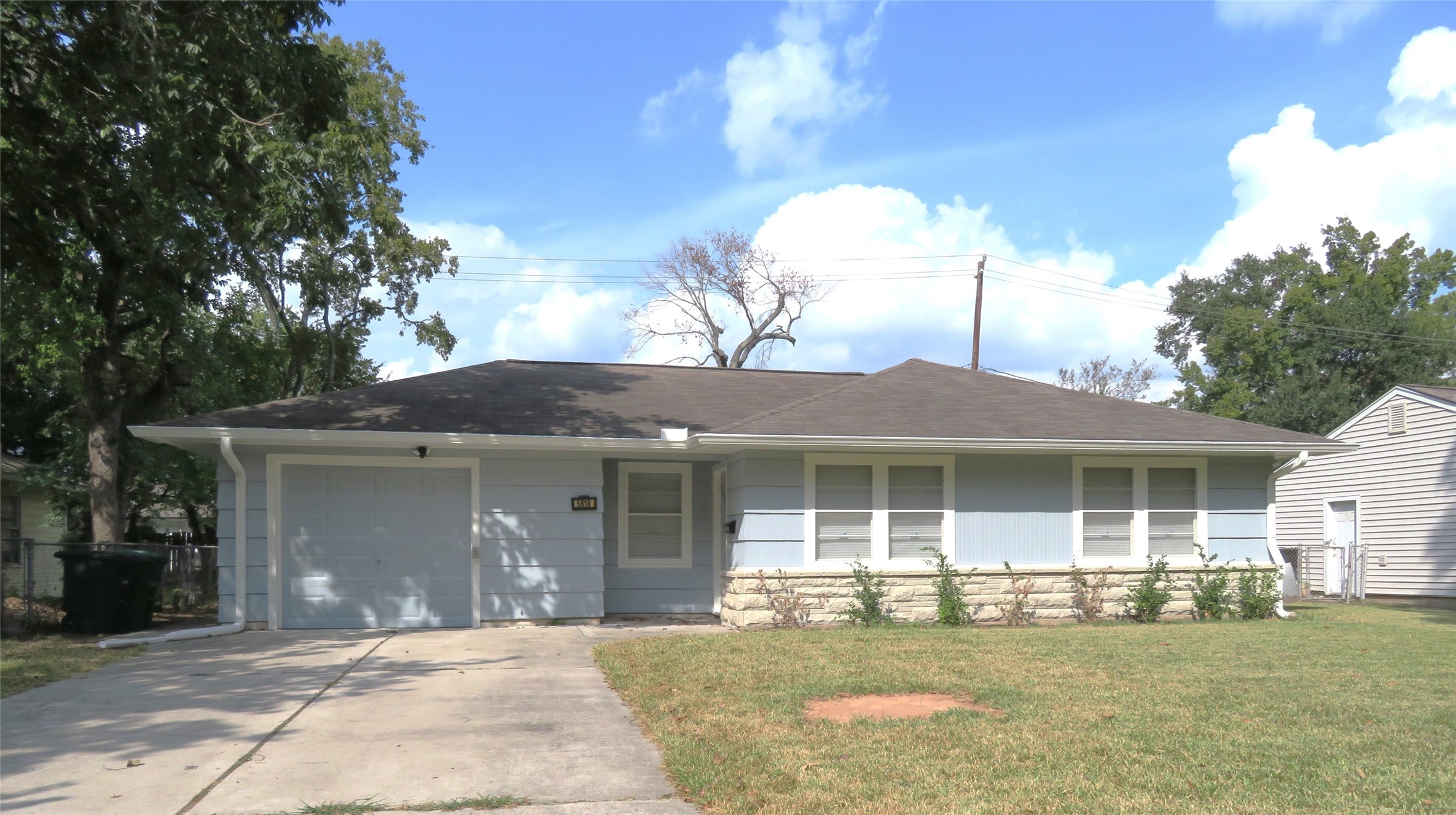 a front view of a house with a garden and yard