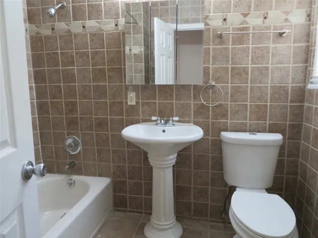 a bathroom with a toilet a sink and mirror