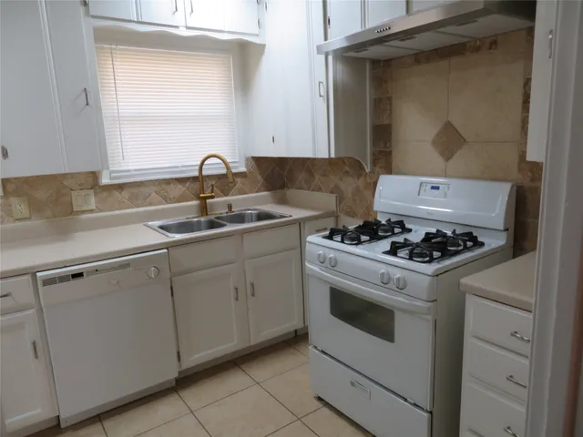 a white stove top oven sitting inside of a kitchen