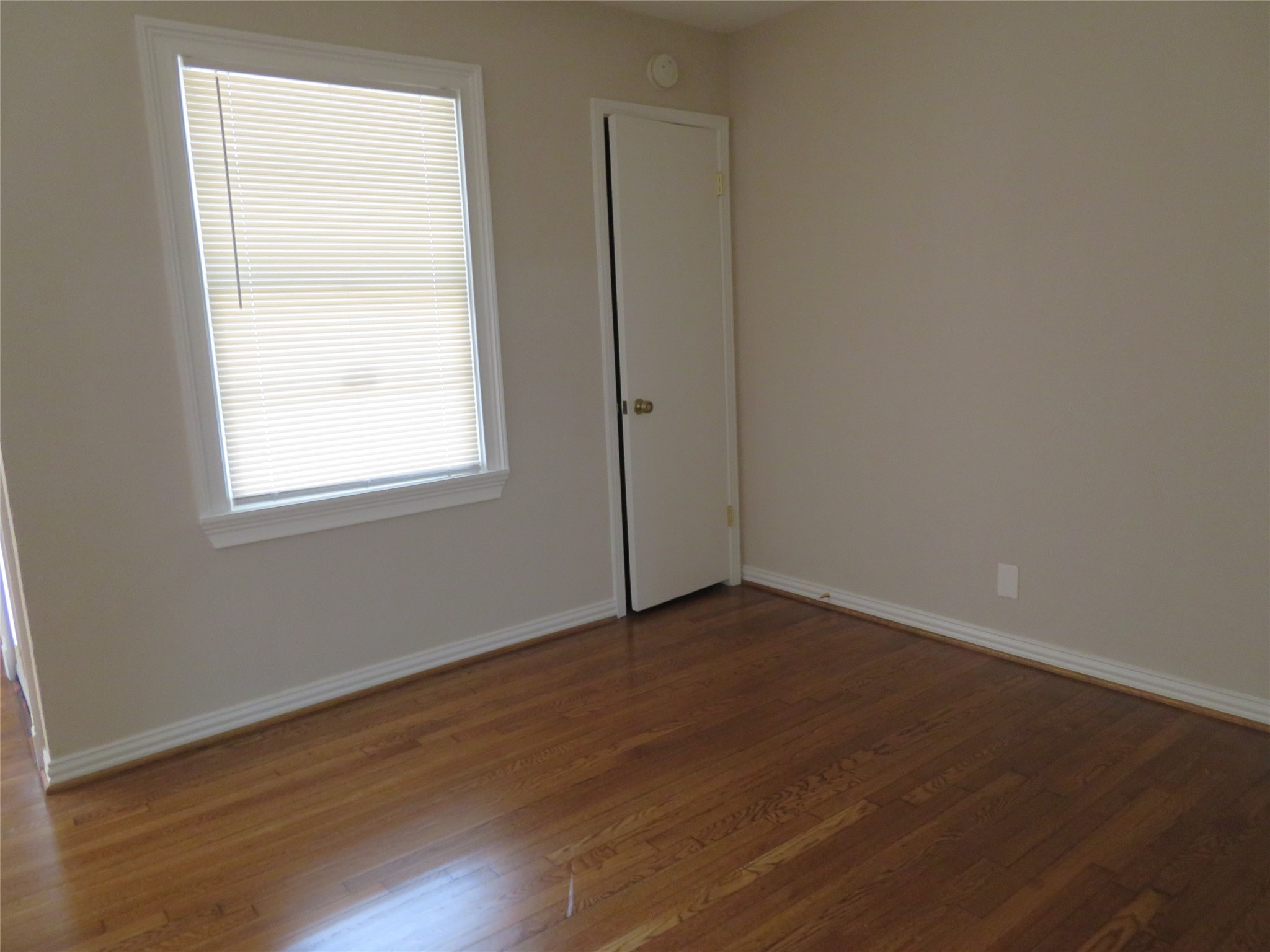 5818 Carew Street Houston, TX 77074 - Photo 8 of 16 an empty room with wooden floor and windows