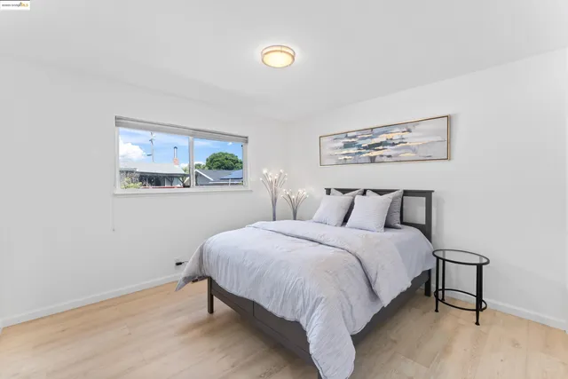 a bedroom with a bed and painting on the wall