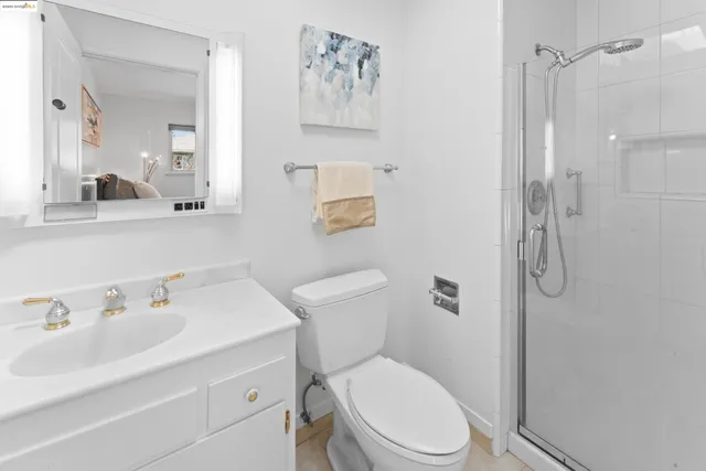a bathroom with a toilet sink vanity and shower