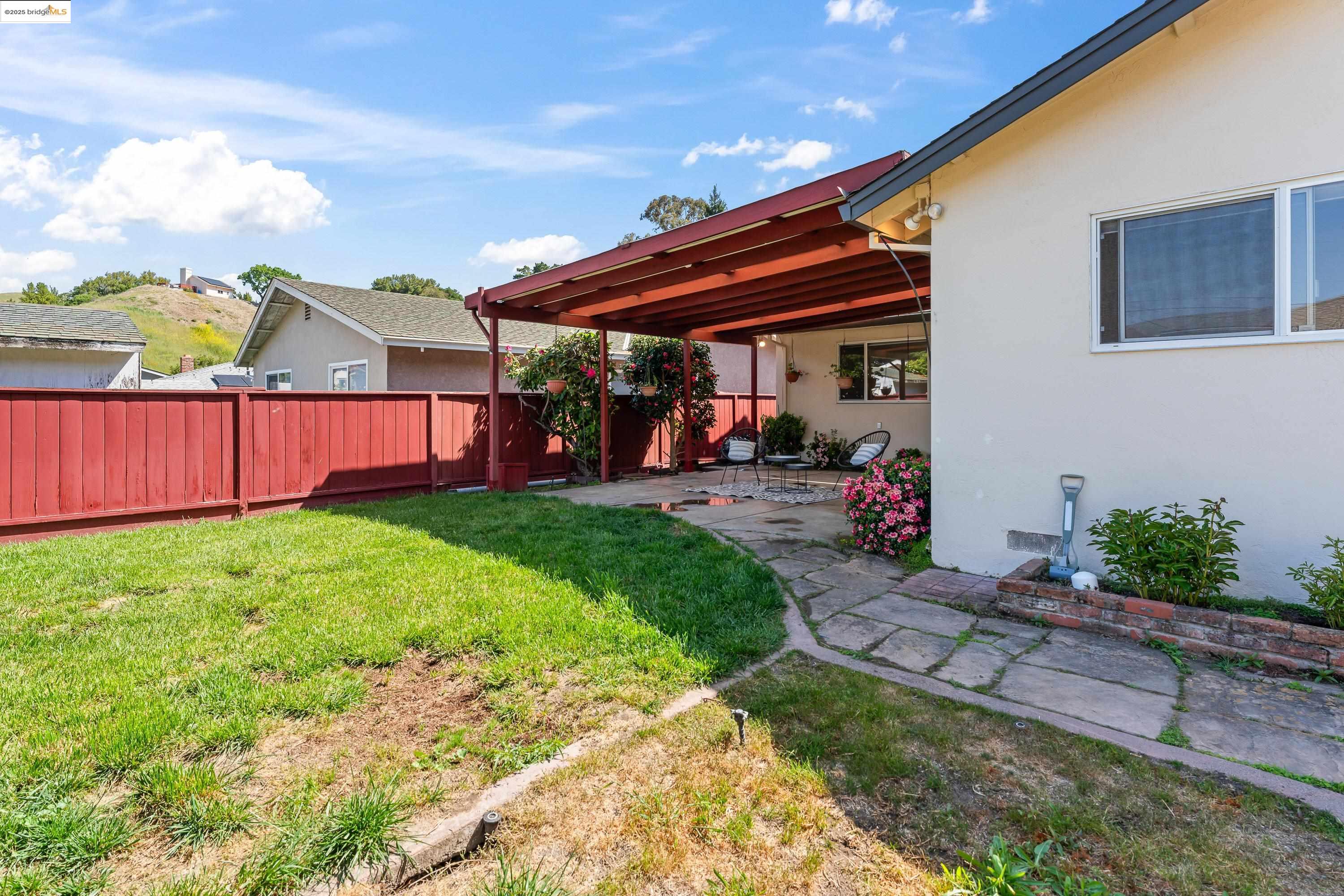 2305 Marlin Court Pinole, CA 94564 - Photo 29 of 31 a view of a backyard with table and chairs under an umbrella
