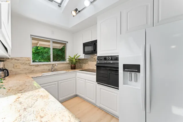 a kitchen with stainless steel appliances kitchen island granite countertop a sink stove and refrigerator