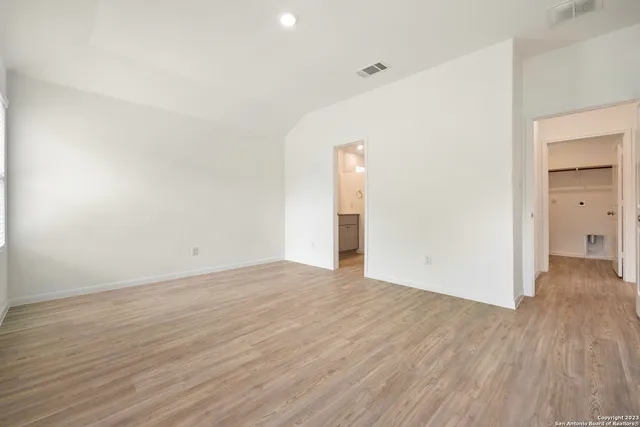 a view of an empty room with wooden floor