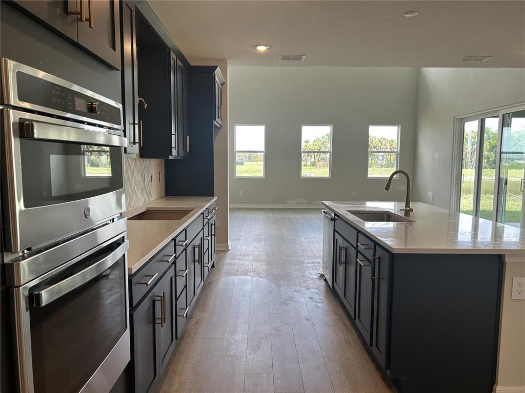 10026 Hidden Hammock Loop Parrish, FL 34221 - Photo 12 of 34 a kitchen with stainless steel appliances a sink and stove