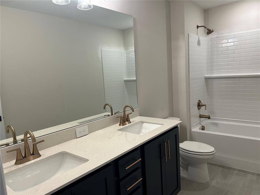 10026 Hidden Hammock Loop Parrish, FL 34221 - Photo 28 of 34 a bathroom with a sink a toilet and shower