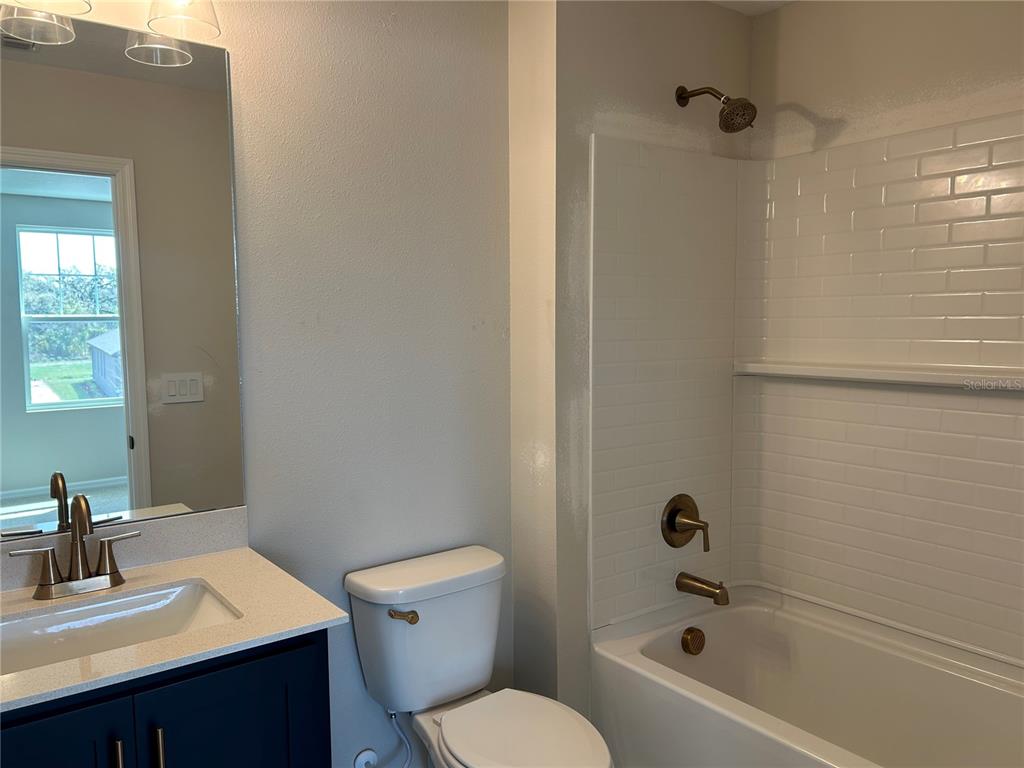 10026 Hidden Hammock Loop Parrish, FL 34221 - Photo 30 of 34 a bathroom with a sink toilet and shower