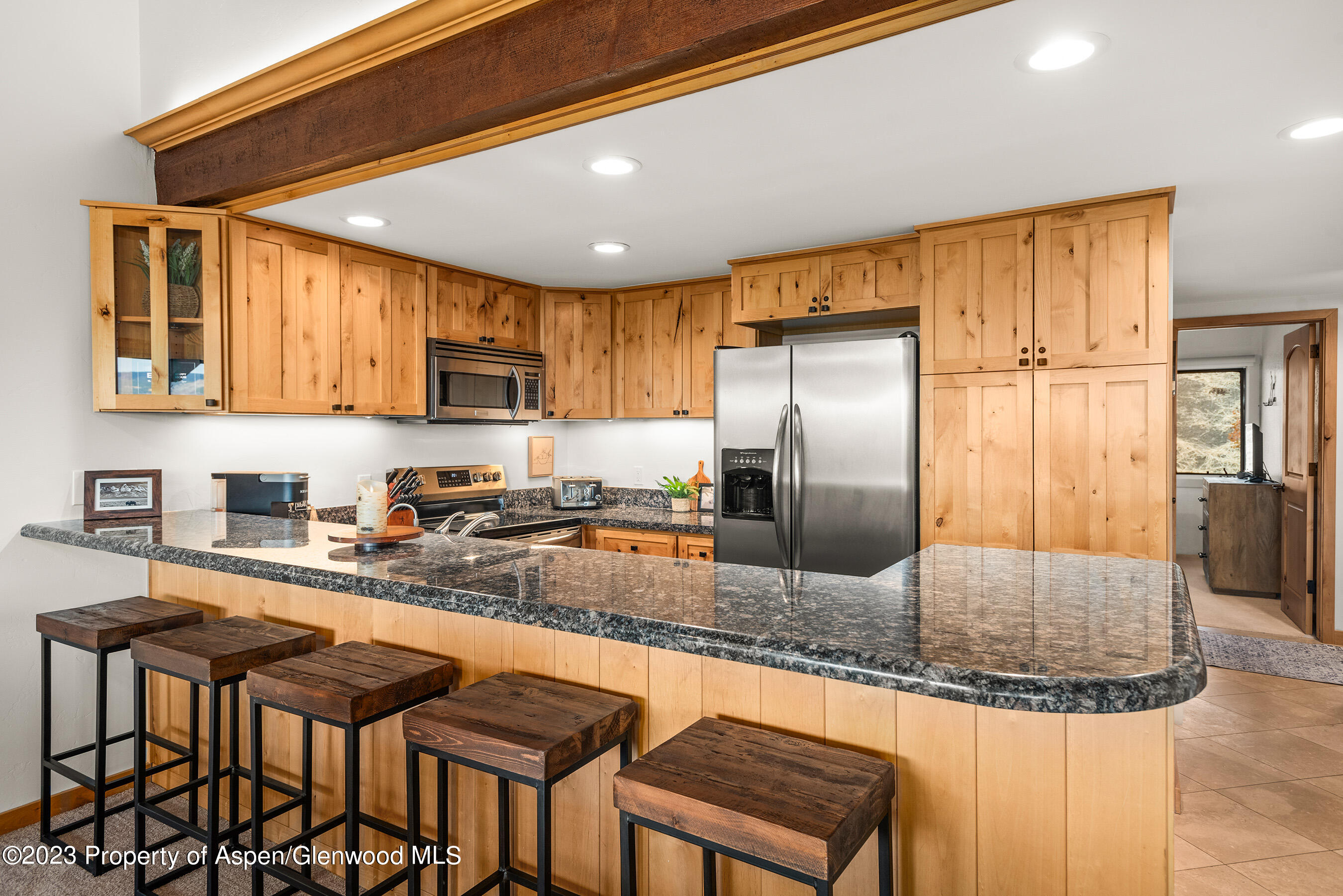 55 Upper Woodbridge Road, Unit G3 Snowmass Village, CO 81615 - Photo 9 of 44 a kitchen with granite countertop a refrigerator a stove a sink and a cabinets