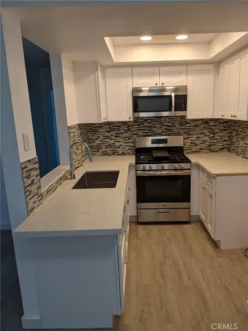 a kitchen with a sink and stainless steel appliances