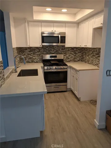 a kitchen with stainless steel appliances a stove and a microwave