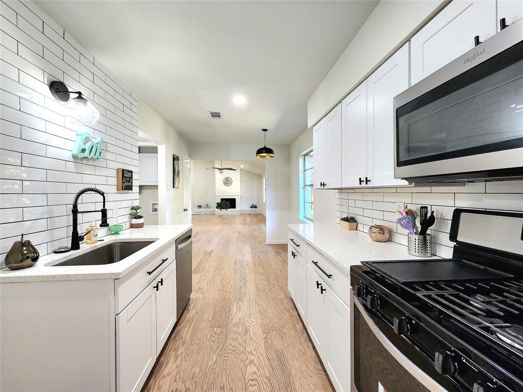 a kitchen with stainless steel appliances a sink stove top oven and cabinets