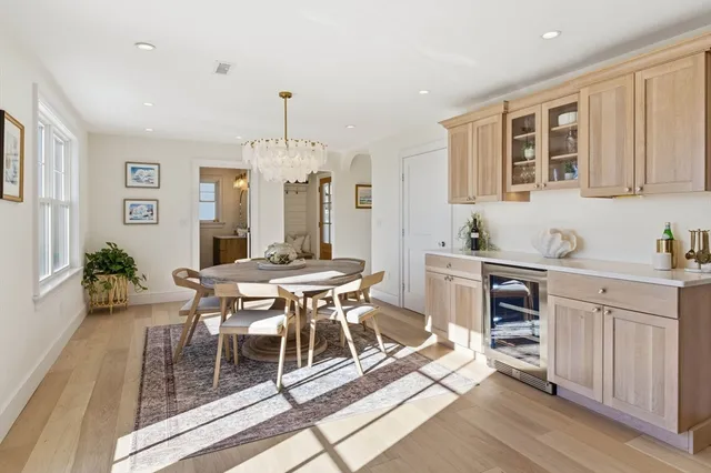 a dining room with stainless steel appliances kitchen island granite countertop a table chairs and a refrigerator