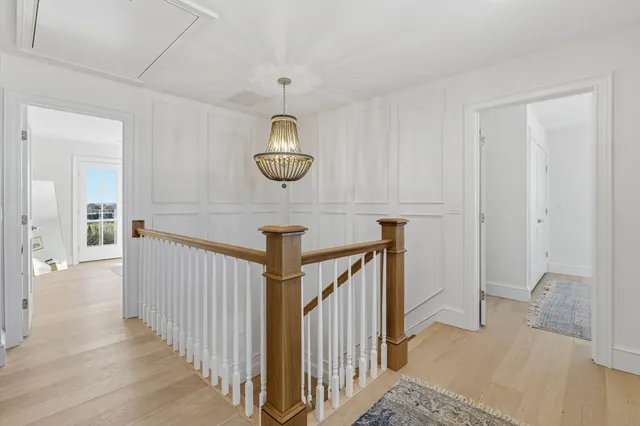a view of a hallway with wooden floor and stairs