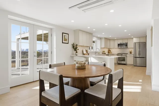 a kitchen with a dining table chairs and refrigerator