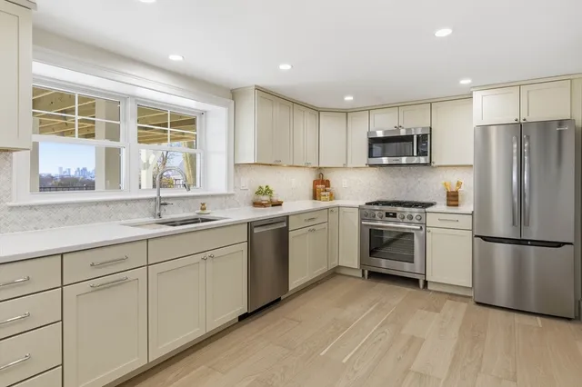 a kitchen with white cabinets and stainless steel appliances