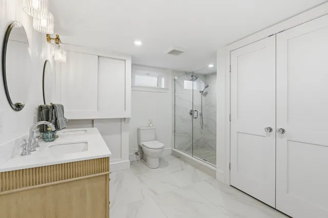 a bathroom with a sink a toilet and shower
