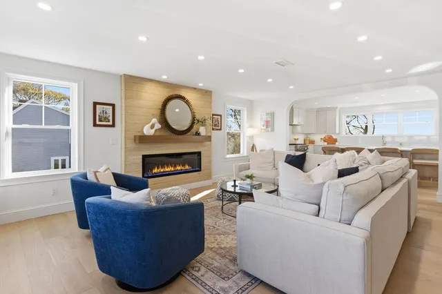 a living room with furniture a fireplace and a large window
