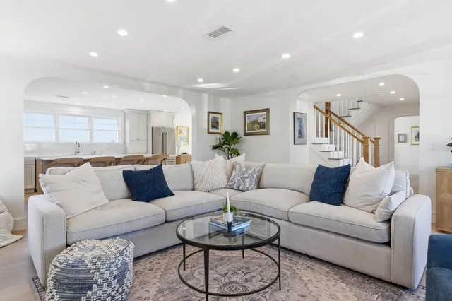a living room with furniture and a large mirror with wooden floor
