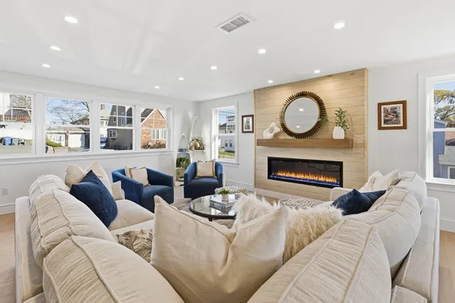 a living room with furniture a clock and a fireplace