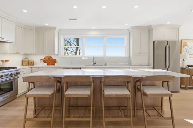 a kitchen with granite countertop a table chairs stove and cabinets