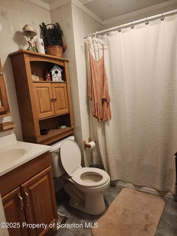 a bathroom with a toilet a sink and curtain