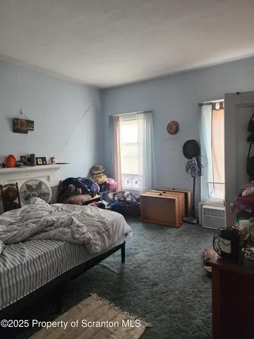 a bedroom with bed and a large window