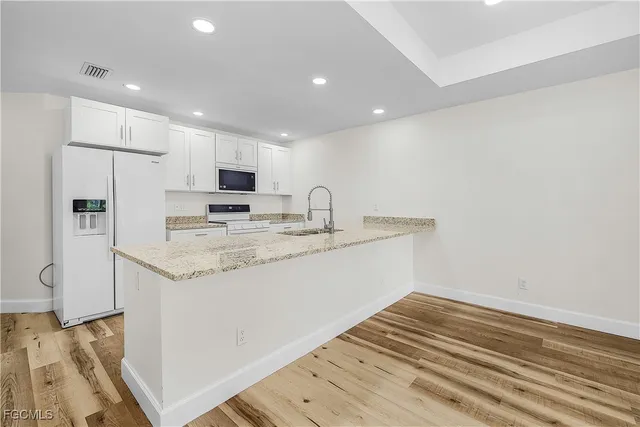 a kitchen with stainless steel appliances granite countertop a refrigerator and a stove top oven