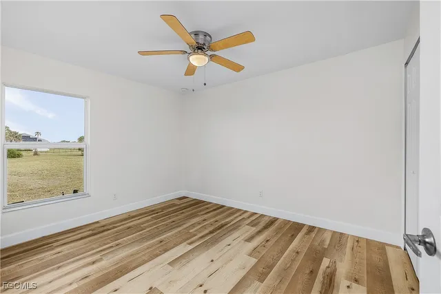 a view of a room with wooden floor and a ceiling fan
