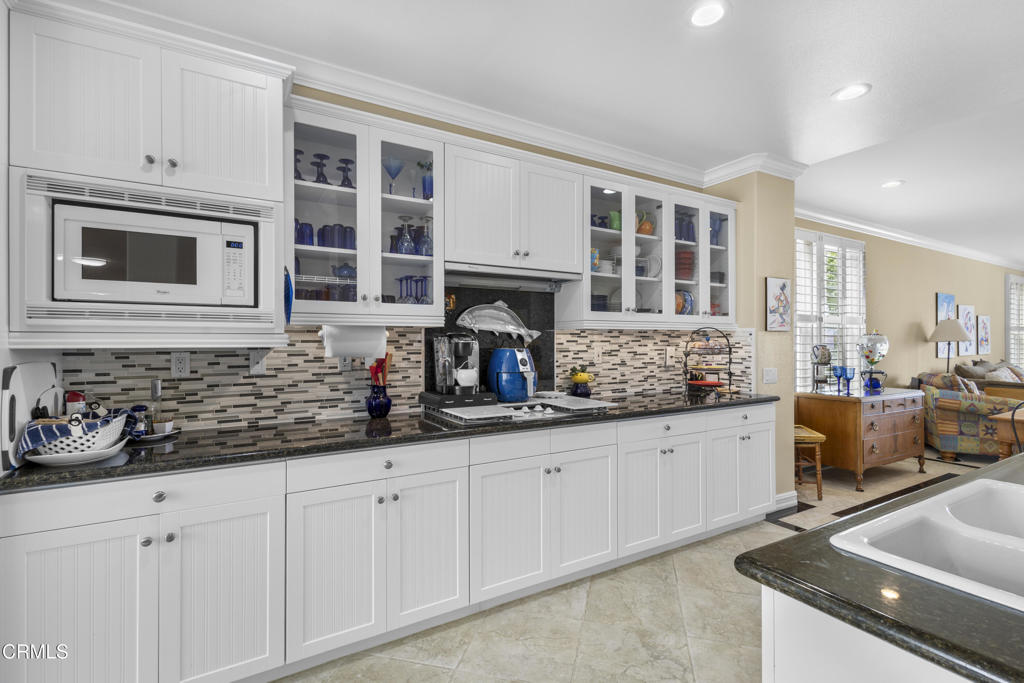 1547 Windshore Way Oxnard, CA 93035 - Photo 4 of 33 a kitchen with granite countertop a stove a sink and white cabinets