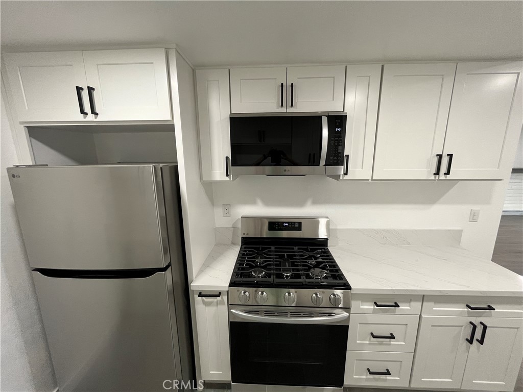 9155 Pacific Avenue, Unit 219 Anaheim, CA 92804 - Photo 11 of 26 a kitchen with a stove and a microwave