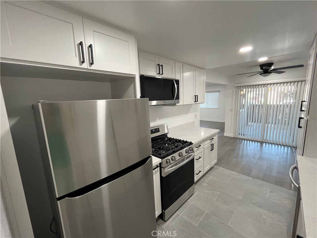 9155 Pacific Avenue, Unit 219 Anaheim, CA 92804 - Photo 12 of 26 a kitchen with stainless steel appliances a refrigerator a stove and a sink
