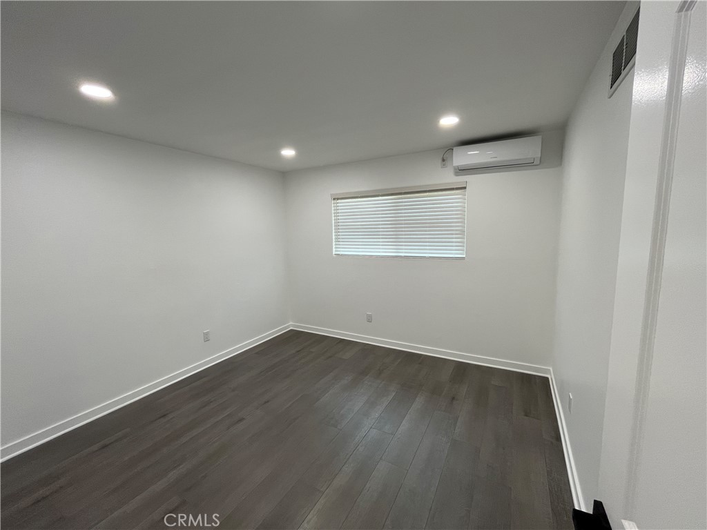 9155 Pacific Avenue, Unit 219 Anaheim, CA 92804 - Photo 18 of 26 an empty room with wooden floor and windows