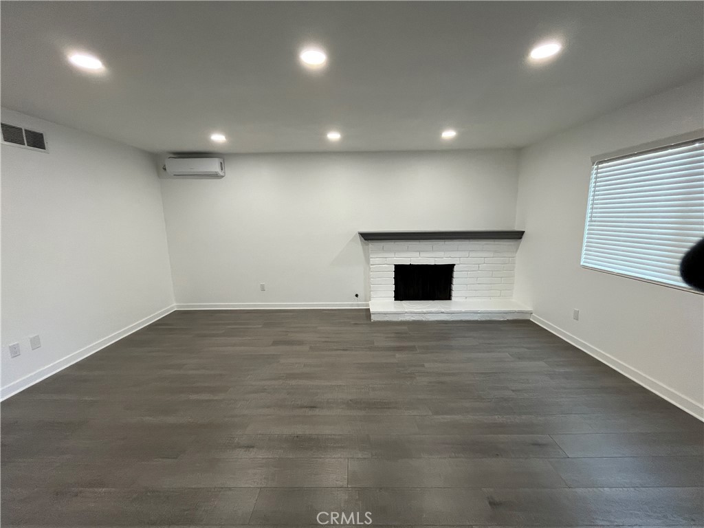 9155 Pacific Avenue, Unit 219 Anaheim, CA 92804 - Photo 2 of 26 an empty room with wooden floor and windows