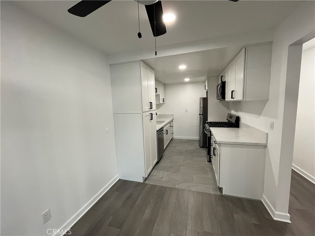 9155 Pacific Avenue, Unit 219 Anaheim, CA 92804 - Photo 7 of 26 a kitchen with a refrigerator and white cabinets