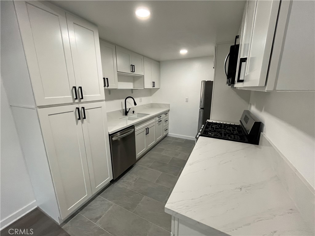 9155 Pacific Avenue, Unit 219 Anaheim, CA 92804 - Photo 10 of 26 a large white kitchen with sink and washing machine