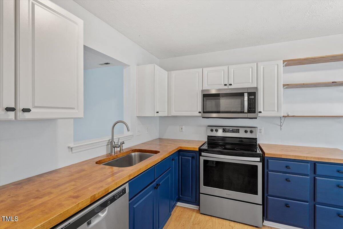2733 Midway Park Court Raleigh, NC 27610 - Photo 11 of 30 a kitchen with sink a microwave a stove and cabinets