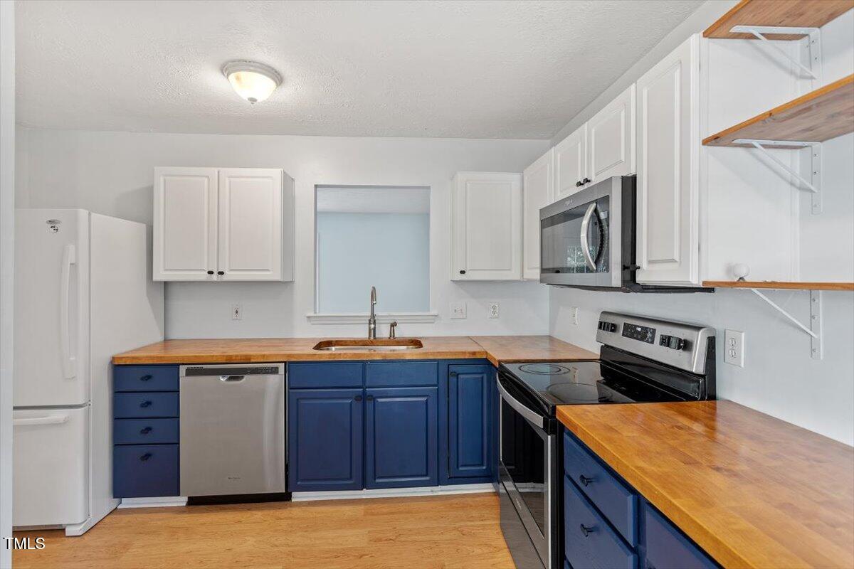 2733 Midway Park Court Raleigh, NC 27610 - Photo 13 of 30 a kitchen with stainless steel appliances granite countertop a sink stove and microwave
