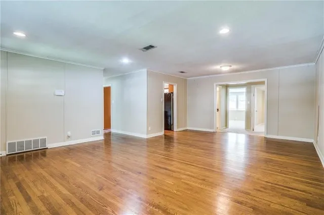 a view of an empty room with wooden floor