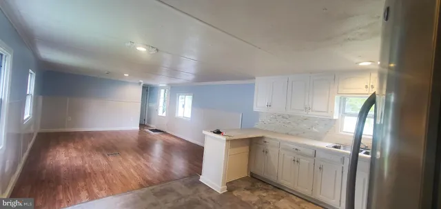 a view of a kitchen with a sink and dishwasher with wooden floor