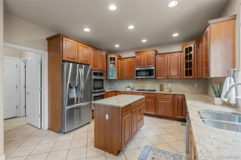 a kitchen with stainless steel appliances granite countertop a refrigerator and a sink