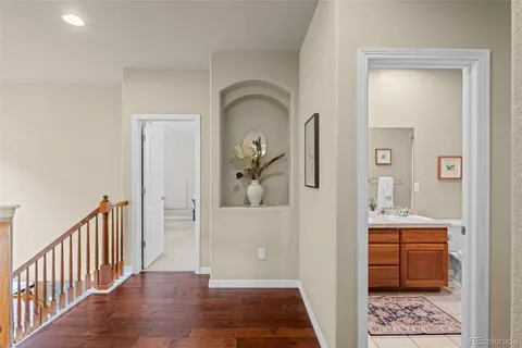 a view of a hallway view with wooden floor and a bathroom