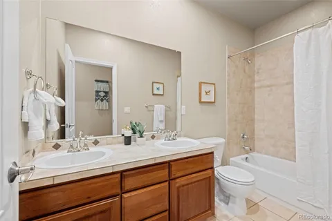 a bathroom with a double vanity sink toilet mirror and shower