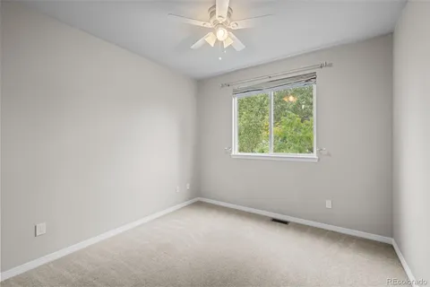 an empty room with a window and a fan