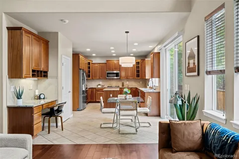 a living room with furniture kitchen view and a large window