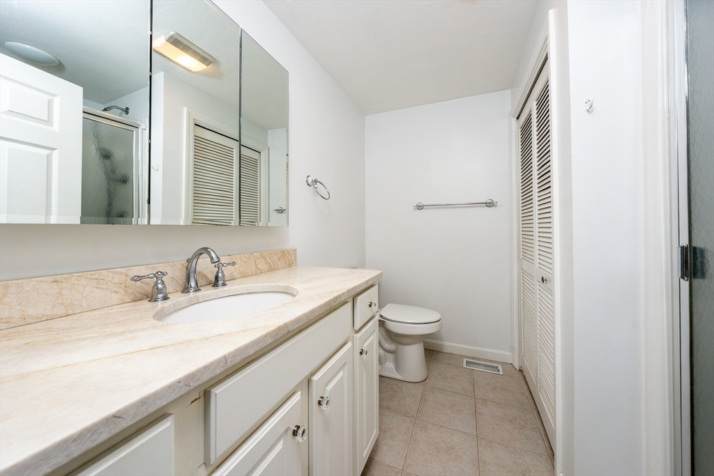 15 Beacon Court, Unit 229 Mashpee, MA 02649 - Photo 12 of 33 a bathroom with a granite countertop sink and a mirror