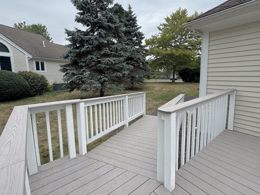 15 Beacon Court, Unit 229 Mashpee, MA 02649 - Photo 18 of 33 a balcony with wooden floor and fence